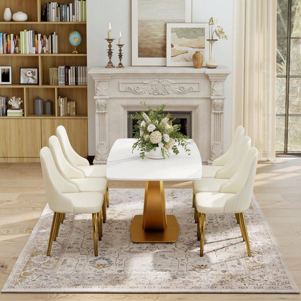 Beige upholstered dining chairs with gold legs arranged around a white marble table.