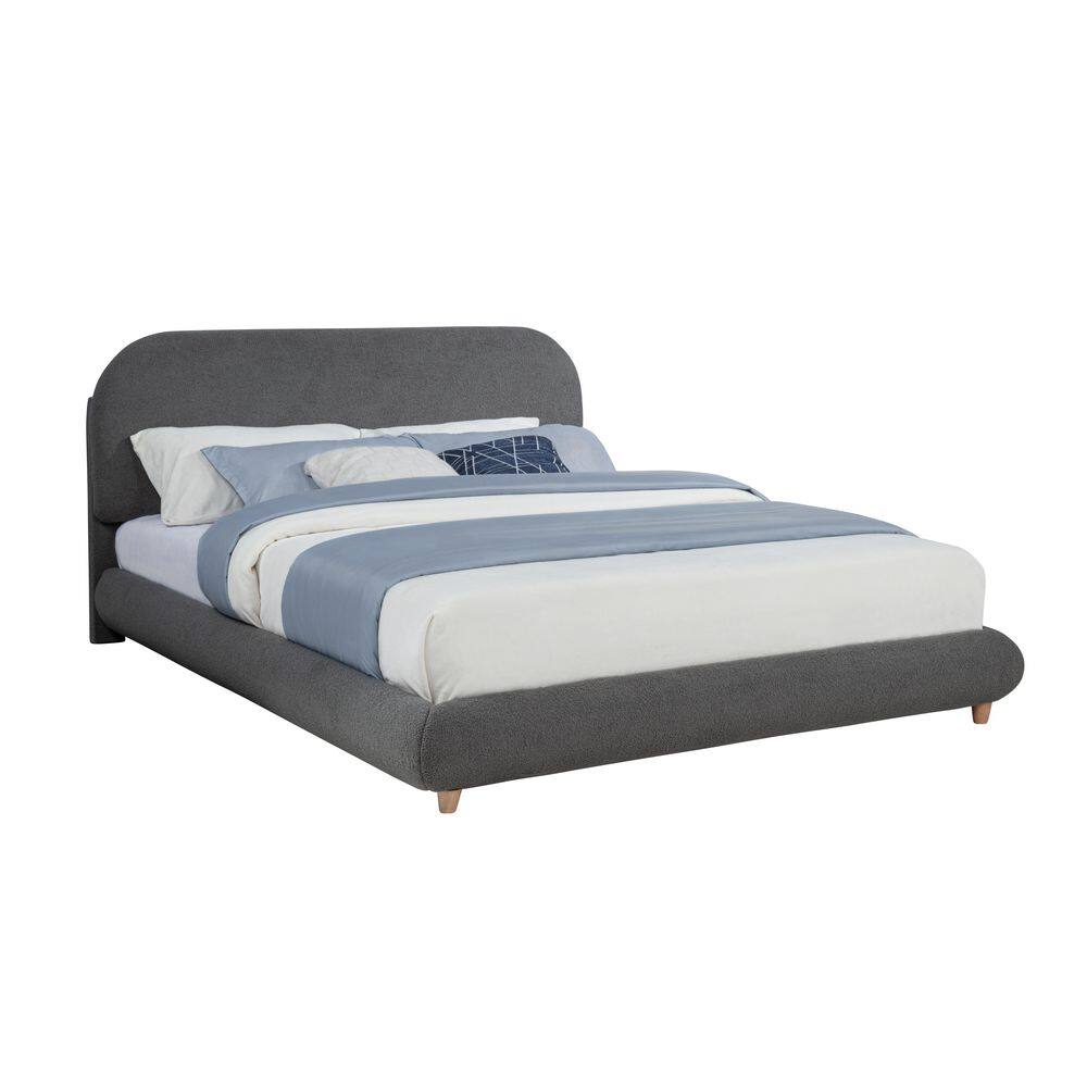 Three-quarter view of a gray upholstered platform bed with a curved headboard.