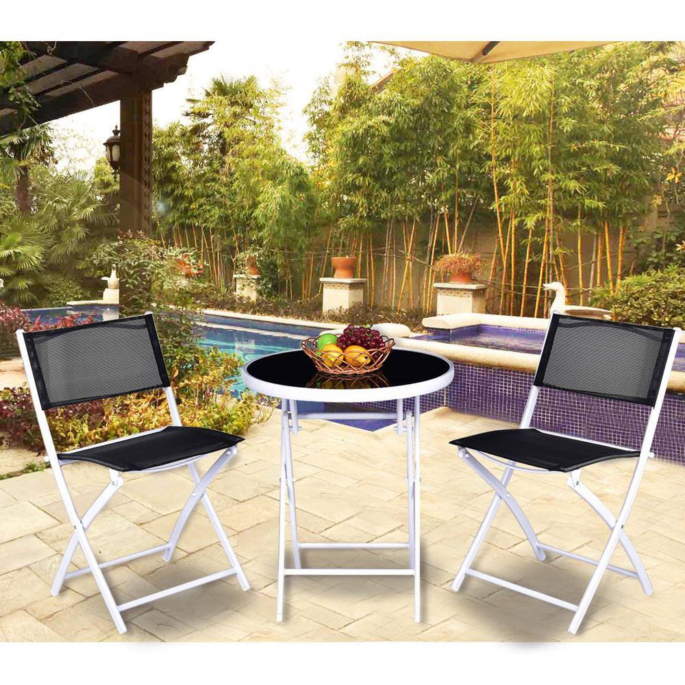 Outdoor bistro set by a pool with greenery.