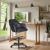 Black faux leather drafting chair in a modern home office setting