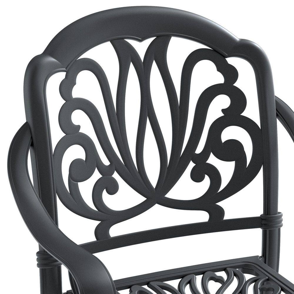 Close-up of the ornate black aluminum scrolled backrest of an outdoor dining chair.