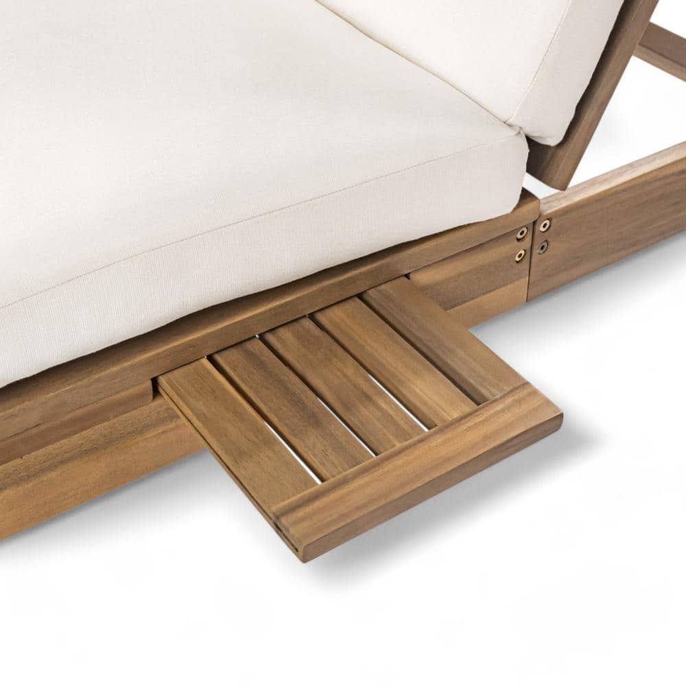 Close-up of the beige cushion and acacia wood frame of the chaise lounge.