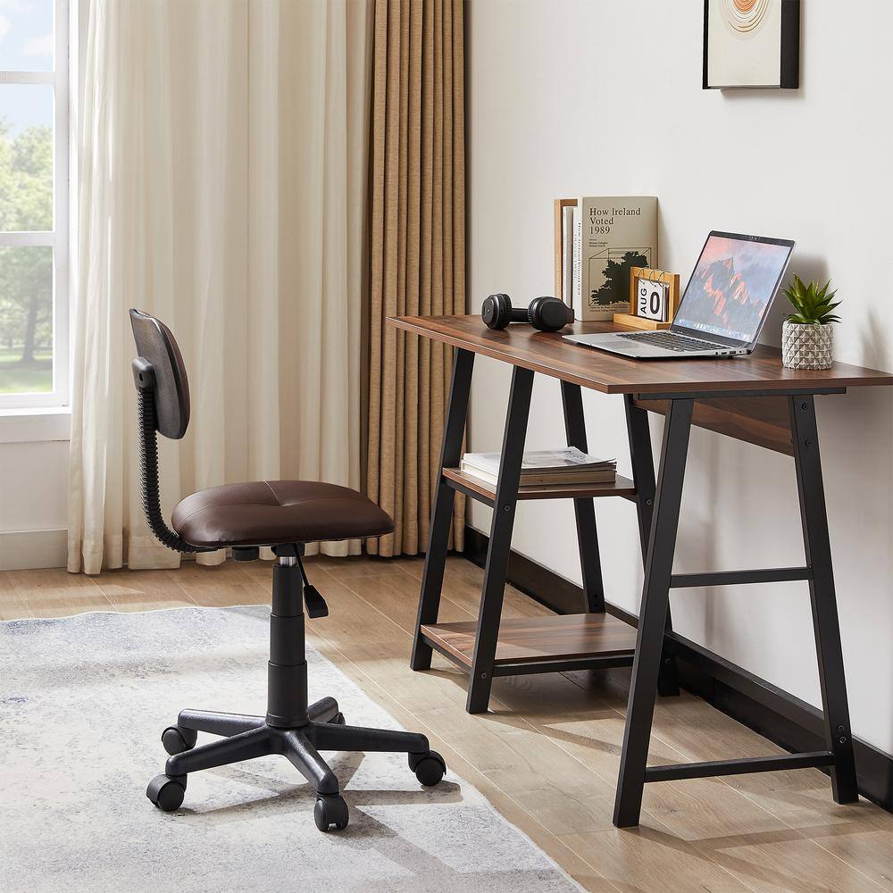Brown faux leather office stool in a room setting next to a wooden desk.