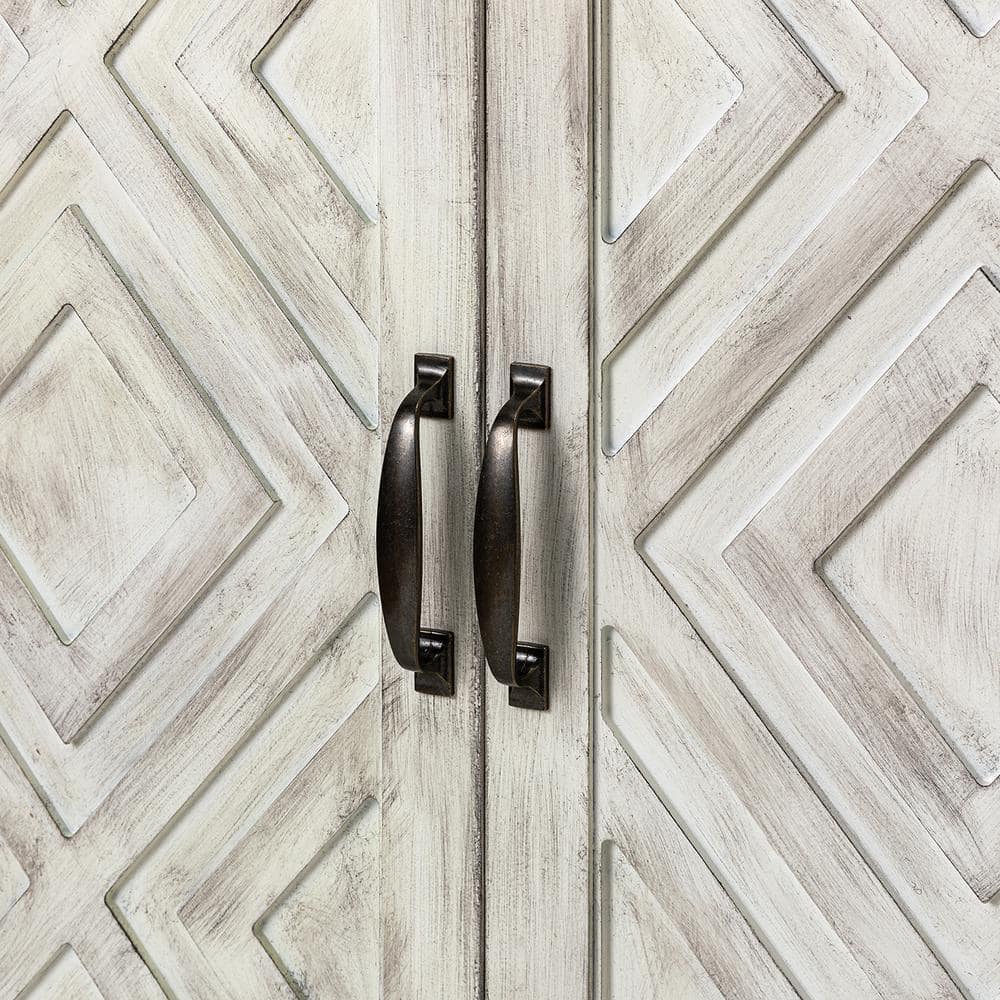 Close-up of the dark metal handles on the white geometric doors of the sideboard.