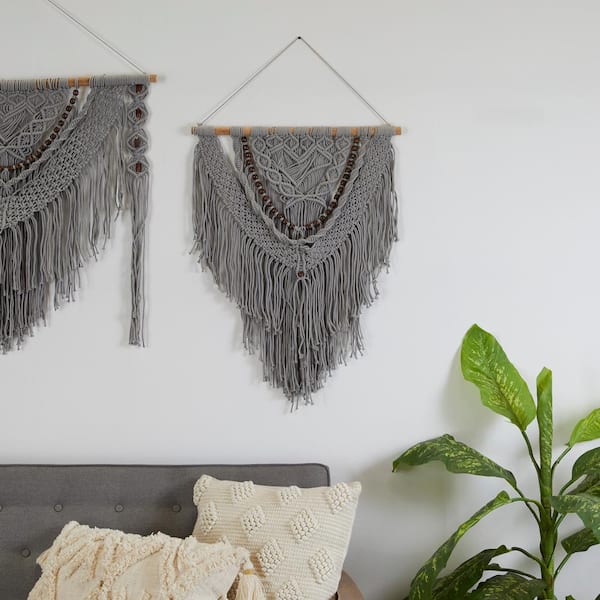 Hand woven black macrame with white beads hanging on wall Stock