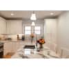Spacious kitchen with white cabinetry, granite countertops, and a large island.
