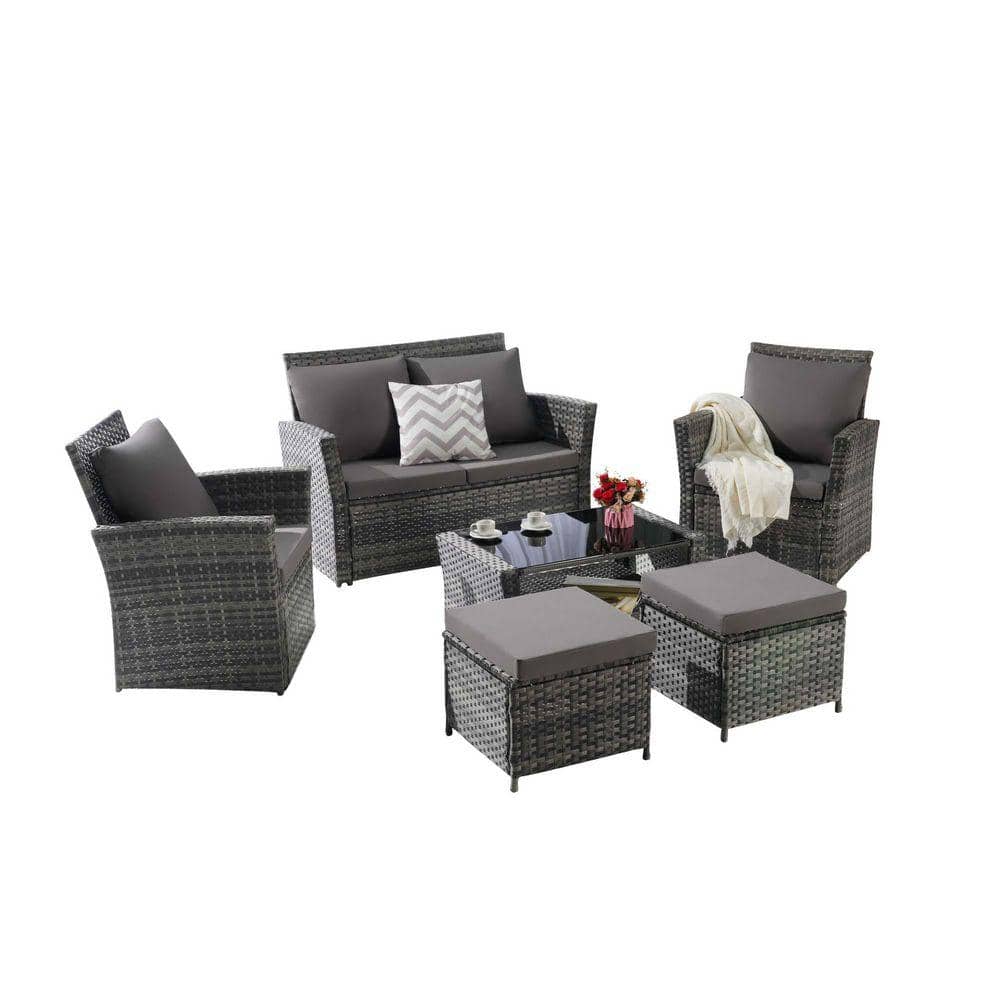Gray wicker outdoor sectional sofa set with dark gray cushions and glass table