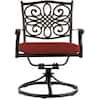 Close-up of an ornate metal outdoor swivel rocker chair with red cushion.