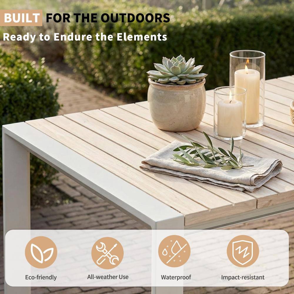 Outdoor dining table set outside with plants and candles.