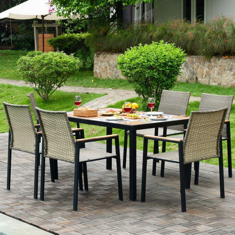 Outdoor dining set in a lush garden setting on a wooden deck.