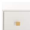 Close-up of a drawer front with a gold knob on a white dresser.