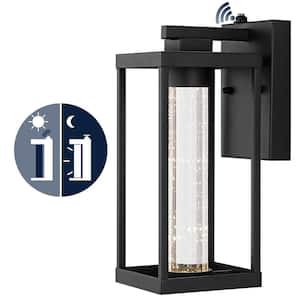 Juno 4.75 in. Black Hardwired Outdoor Cylinder Sconce Iron/Seeded Glass with Dusk-to-Dawn Sensor Integrated LED 1-Light